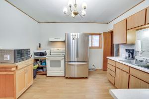 a kitchen with stainless steel appliances and wooden cabinets at Peaceful Channing Retreat 3 Mi to Lake Access! in Channing