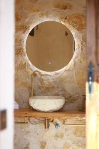 Baño de piedra con lavabo y espejo en La Casa del Cantero, en Pinilla del Valle