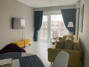a living room with a couch and a bed and a window at Apartamentul Max, practic și confortabil in Oradea