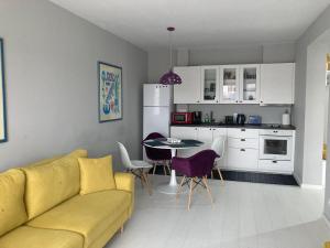 a living room with a yellow couch and a kitchen at Apartamentul Max, practic și confortabil in Oradea