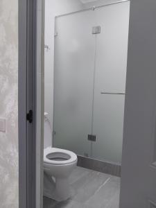 a bathroom with a toilet and a glass shower at Квартира in Shymkent