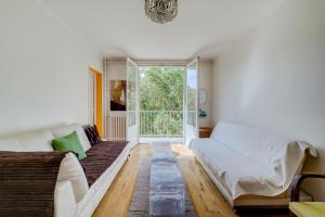 un soggiorno con divano e una grande finestra di Brienne by Yumē a Tolosa