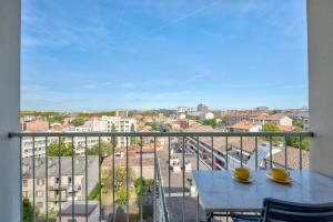a balcony with a table and a view of a city at Brienne by Yumē in Toulouse