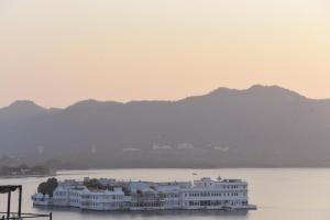 a large white building in the middle of a river at Sajjan Villa in Udaipur