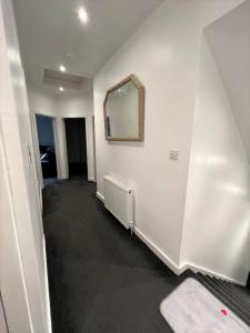an empty room with a mirror and a hallway at Lovely 2 Bed Apt close to Silverburn Mall in Glasgow
