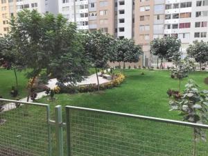 a park with a fence and trees and buildings at Departamento en Condominio Comas in Lima