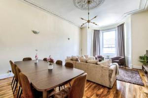 a living room with a table and a couch at Stunning 5 bedroom apt, close to city centre, SEC, Hydro and motorway in Glasgow