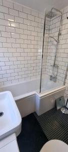a white bathroom with a shower and a toilet at Beautiful 2 bed house close to M74 and Strathclyde Park in Motherwell