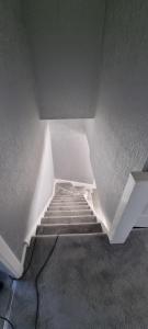 a hallway with a staircase in a room with a stair case at Beautiful 2 bed house close to M74 and Strathclyde Park in Motherwell