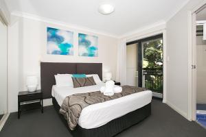 a bedroom with a large bed and a large window at Sandcastles On The Broadwater in Gold Coast