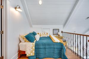 a bedroom with a bed with a blue comforter at Lakefront New London Retreat with Dock and Hot Tub! in New London