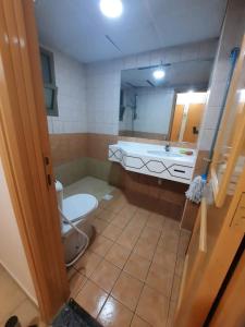 uma casa de banho com um WC, um lavatório e um espelho. em DUBAI MALL METRO Executive room no Dubai