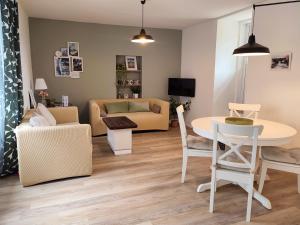 a living room with a table and a couch at Gite Le 1900 in Antrain