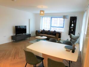 a living room with a table and a couch at Brand new gorgeous 2 bed Apt in Finnieston in Glasgow