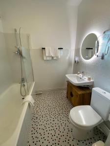 La salle de bains blanche est pourvue de toilettes et d'un lavabo. dans l'établissement Balzac Hôtel, à Fougères
