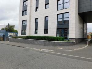 a building on a street next to a road at Brand new gorgeous 2 bed Apt in Finnieston in Glasgow