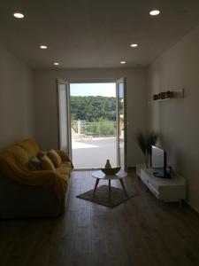 a living room with a couch and a tv and a table at Apartments Antonia in Hvar