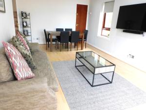 a living room with a couch and a glass coffee table at Charming 2 bed apt close to City and SEC Hydro in Glasgow