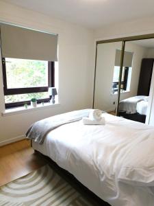 a bedroom with a large white bed and a window at Charming 2 bed apt close to City and SEC Hydro in Glasgow