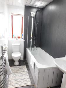 a bathroom with a tub and a toilet and a sink at Charming 2 bed apt close to City and SEC Hydro in Glasgow