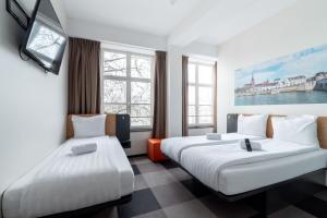 a hotel room with two beds and windows at easyHotel Maastricht City Centre in Maastricht