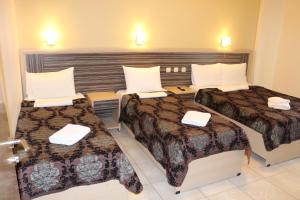 a hotel room with two beds and two tables at Villa-Andromeda in Paralia Katerinis