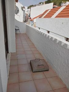 a stone box sitting on a tiled floor next to a building at Traditional House with 2 floors - 5 minutes from Beach in Salema