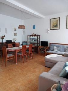 a living room with a couch and a table and chairs at Traditional House with 2 floors - 5 minutes from Beach in Salema