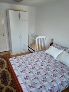 ein Schlafzimmer mit einem Bett und einem Kinderbett in der Unterkunft Stan na dan Bega in Modriča