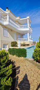a large house with a swimming pool in front of it at Villa Ulyana Kriaritsi - Athos Sea View & Spa in Kriaritsi