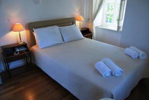 een slaapkamer met een bed met twee handdoeken erop bij Hotel Miranda in Hydra