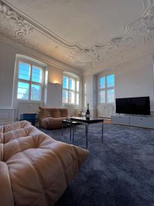 uma sala de estar com um sofá e uma televisão de ecrã plano em Luxuriöse Design Wohnung im Barockschloss 110 m2 em Zeitlofs