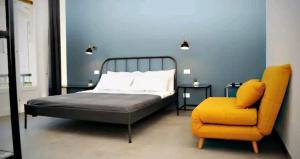 阿梅利亞的住宿－Debirooms，一间卧室配有一张床和一张黄色椅子