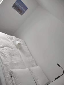 un letto bianco con lenzuola e cuscini bianchi di Ilulissat Hostel a Ilulissat
