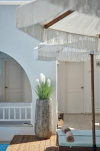 a patio with an umbrella and a chair and a couch at Stelia Mare Boutique Hotel in Naousa