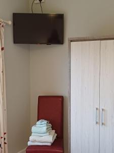 uma pilha de toalhas sentadas numa cadeira vermelha num quarto em Joan B+B em Clonakilty