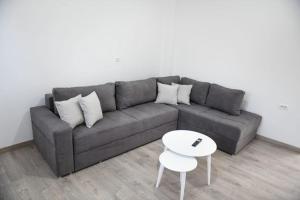 sala de estar con sofá gris y mesa blanca en Villa Kaceli en Berat