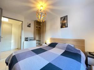 - une chambre avec un lit bleu et blanc et un lustre dans l'établissement Manoir by Yumē, à Toulouse