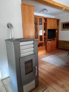 ein Wohnzimmer mit einem Kühlschrank und einem TV in der Unterkunft Ferienhaus Waldenstein 1 in Wolfsberg
