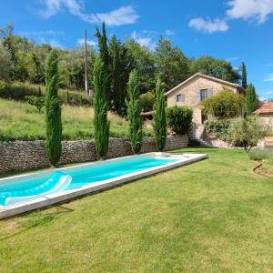 a swimming pool in a yard with trees at Le Ptit Cottage in Nyons