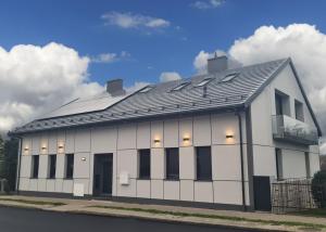 a white building with a black roof at Apartment Quiet Street 11/1E in Oświęcim