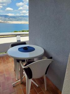 einen weißen Tisch und Stühle mit Meerblick in der Unterkunft Apartmani Vesna in Pag