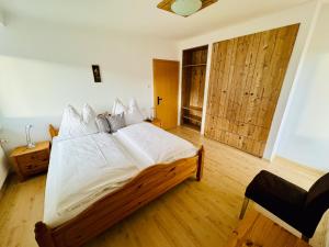 Un dormitorio con una gran cama de madera con sábanas blancas. en Ferienhaus Am Hofacker en Aflenz Kurort