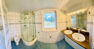 bagno con 2 lavandini, vasca e doccia di Ferienhaus Am Hofacker ad Aflenz Kurort