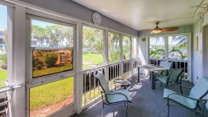 a screened porch with chairs and a table and windows at Sunset Serenade in Welaka in Georgetown