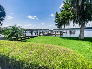 a dock on a body of water with trees and grass at Sunset Serenade in Welaka in Georgetown