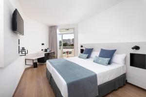 Dormitorio con cama, escritorio y TV en Alexandre Hotel Troya en Playa de las Américas