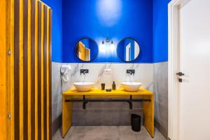2 lavandini in un bagno con pareti e specchi blu di The Place a Napoli