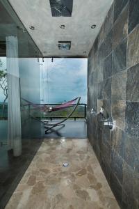 a bathroom with a hammock in a room with a window at Kura Boutique Hotel Member of the Cayuga Collection in Uvita