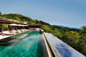 a swimming pool with solar panels next to a resort at Kura Boutique Hotel Member of the Cayuga Collection in Uvita +56 photos